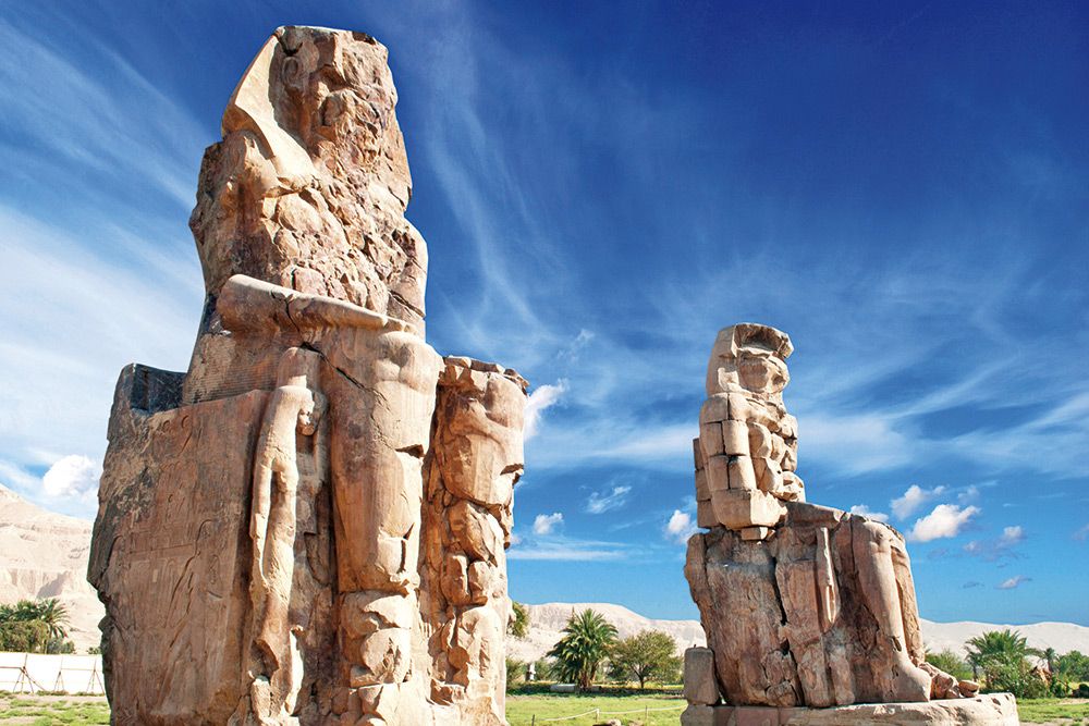 Memnonovy kolosy - dvě sedící obří sochy znázorňující faraona Amenhotepa III.