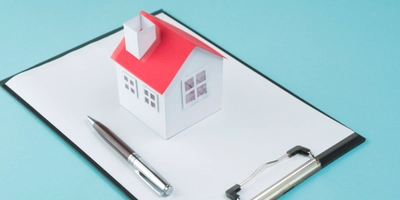 Small house model pen blank clipboard blue backdrop