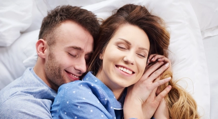 Young couple hugging bed morning