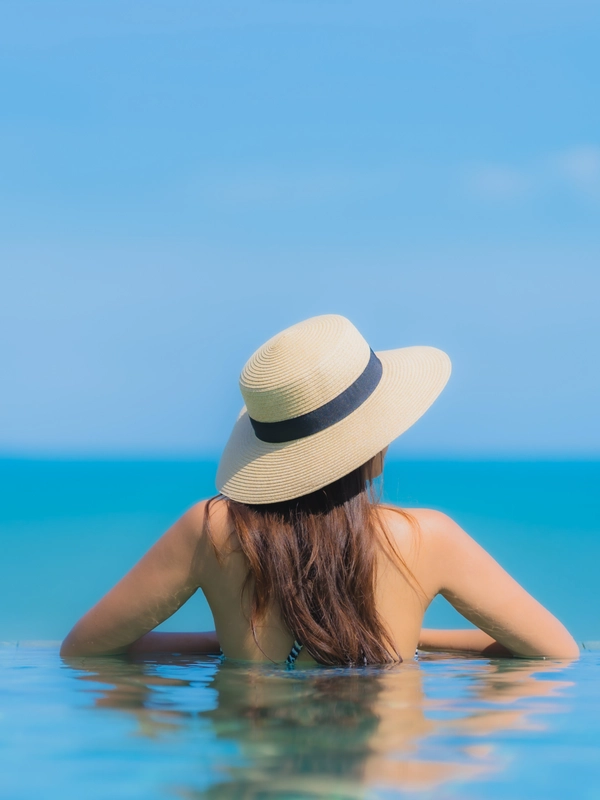 Portrait beautiful young asian woman happy smile relax swimming pool hotel resort neary sea ocean beach blue sky