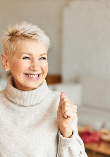 Indoor shot fashionable overjoyed mature female turtleneck sweater enjoying positive news having ecstatic facial expression laughing clenching fists success achievements concept