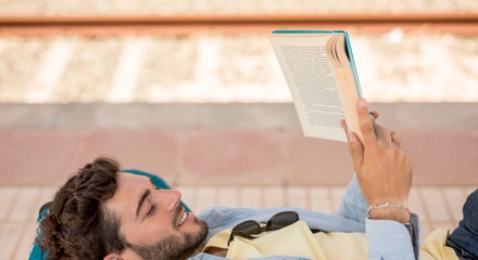 Sideways man reading book train staion