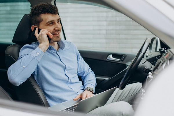 Man working laptop inside his car