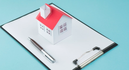 Small house model pen blank clipboard blue backdrop